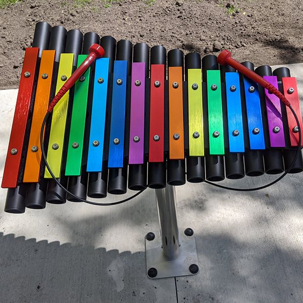 rainbow colored outdoor xylophone with an outdoor music book in the north mankato taylor library music garden