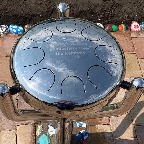 an engraved memorial stainless steel outdoor drum for a school sensory garden in memory a a former pupil