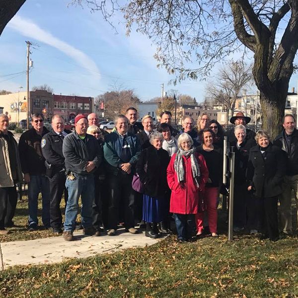 group of beaver dam rotary members stood beside new riverwalk outdoor music trail for grand opening