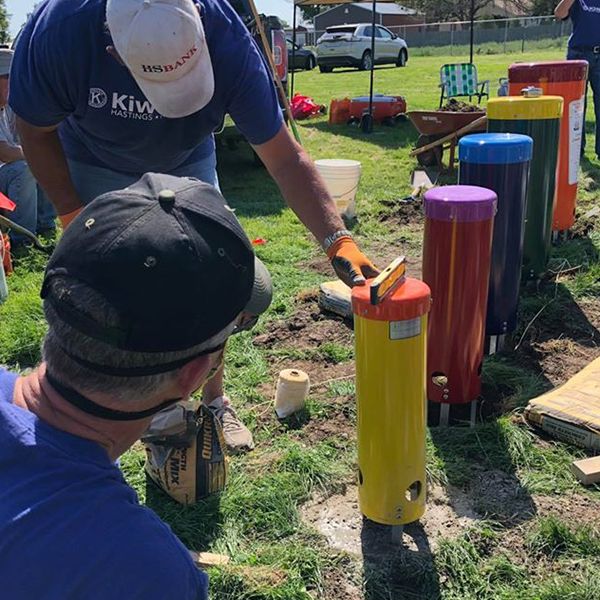 three men from Hastings Noon Kiwanis team installing outdoor musical instruments in the Alcott Elementary School Playgound