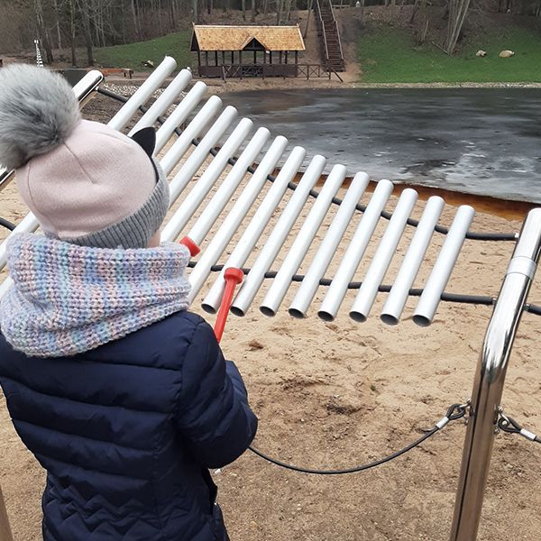 Children playing the outdoor musical instruments in the new playground at the Sirvetos Regional Park Lithuania