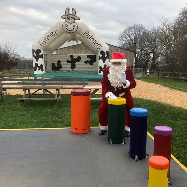 image of Father Christmas playing outdoor musical instruments at Farmer Palmers Farm Park