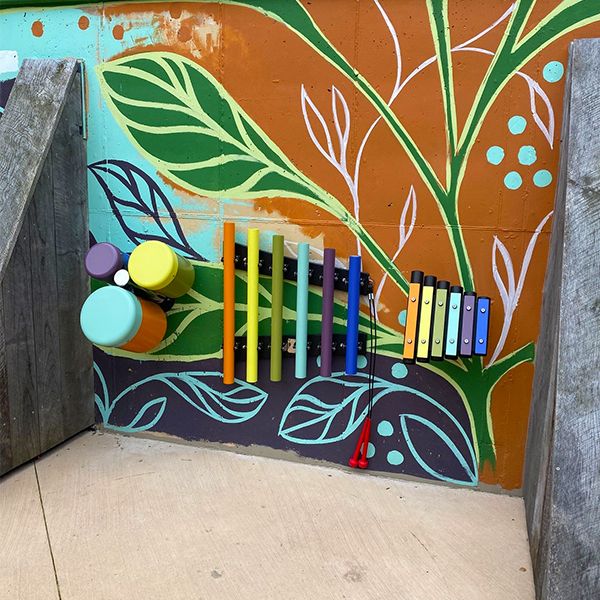 a set of three outdoor musical instruments fixed to a wall at the Madison Childrens Museum