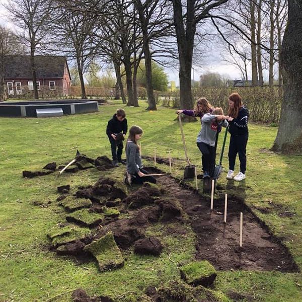 school children removing the turf and digging holes ready for their new outdoor musical instruments