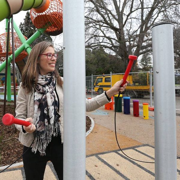 a music therapist playing on a set of tall tubular bells in a new inclusive musical playground in new zealand