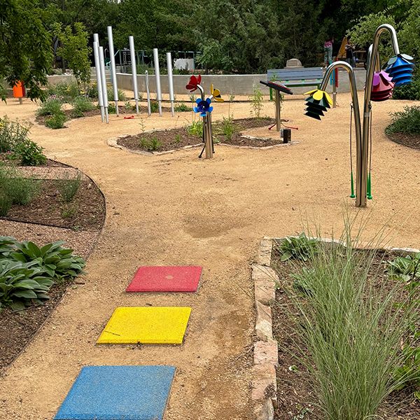 a collection of outdoor musical instruments in the garden of Santa Fe Children's Museum